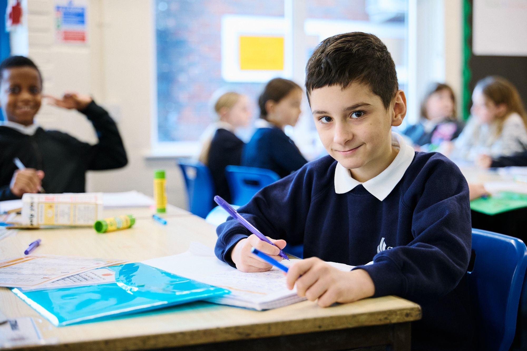 Child writing in a classroom