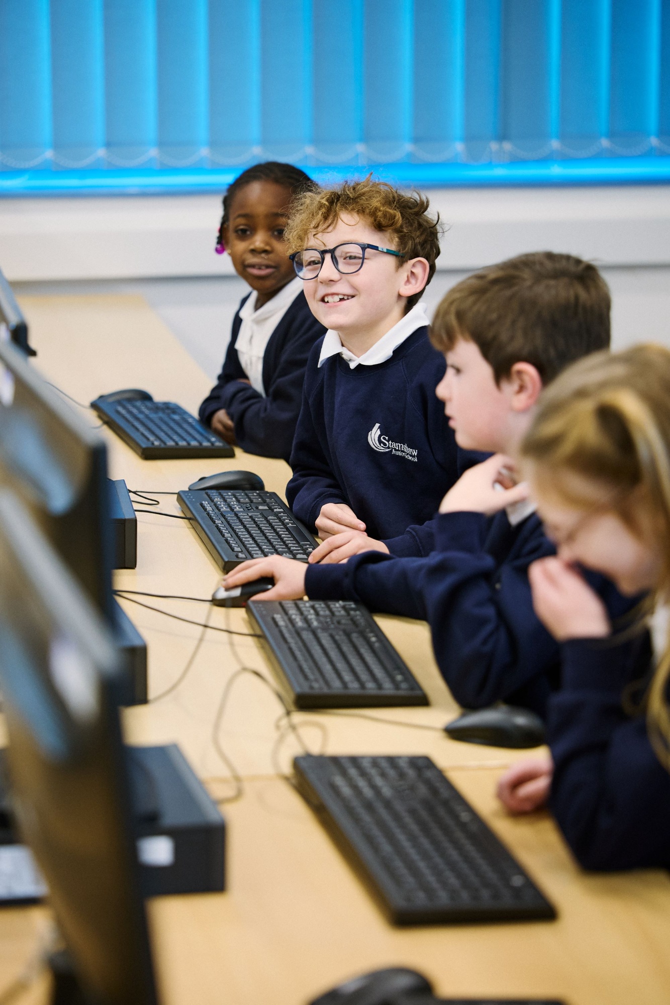 Boy smiling in school computer suite