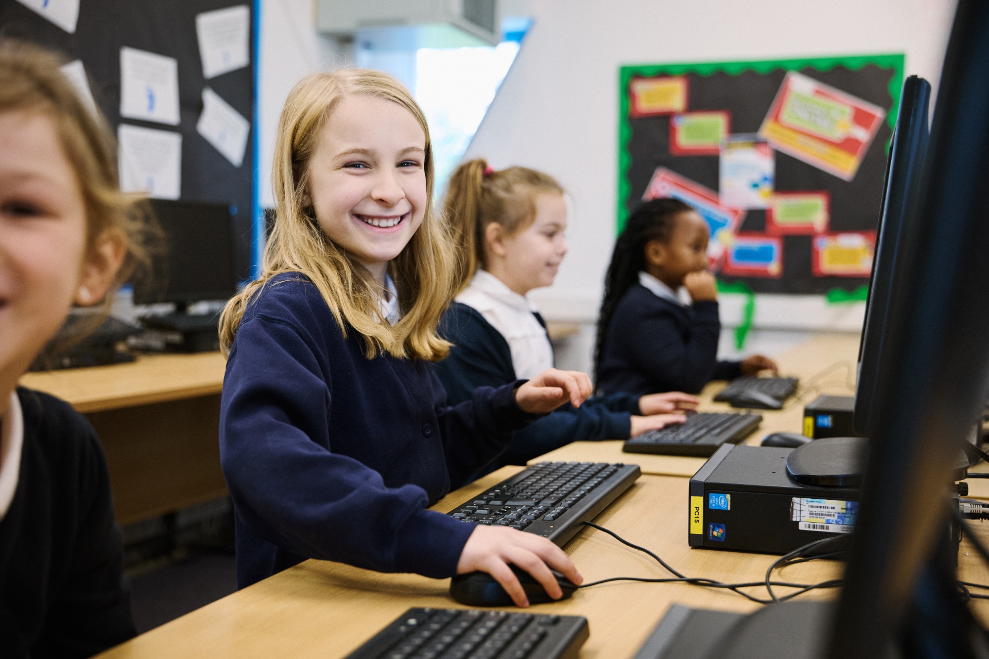 Children smiling and using a computer